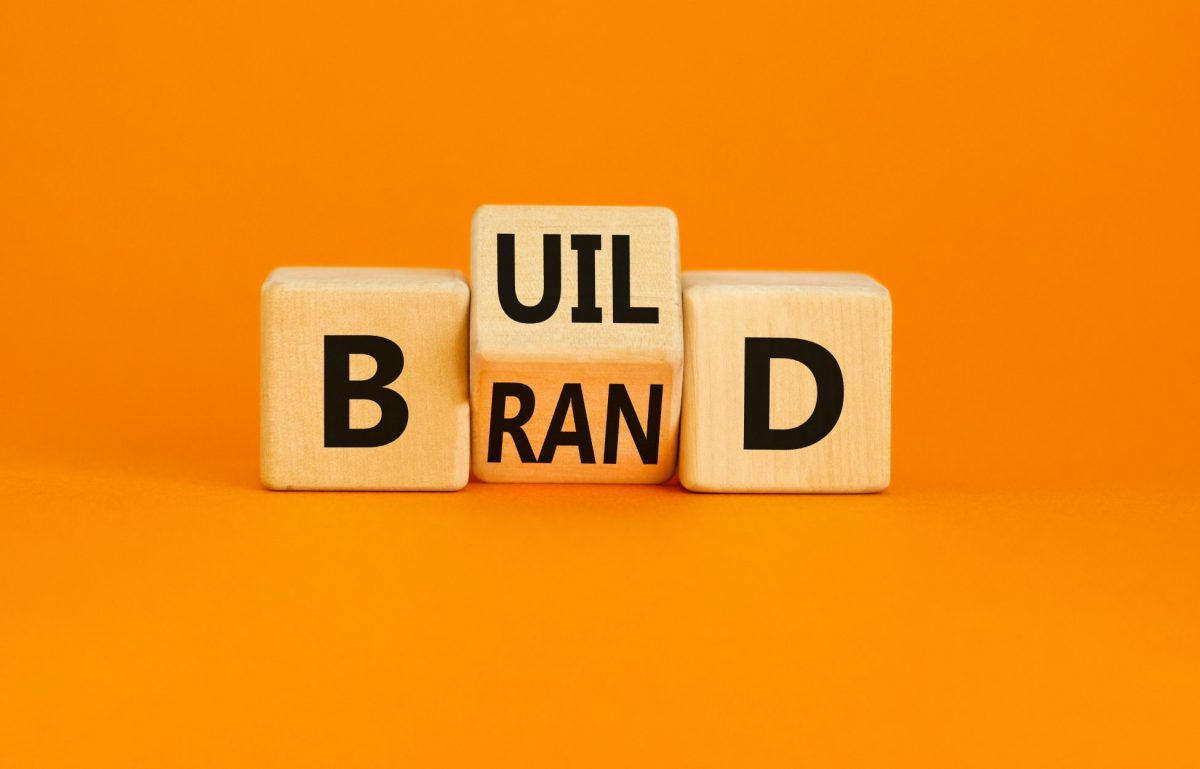 Wooden cubes with the words "Build brand" with an orange background to symbolize the concept of building your brand.