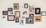 A photo gallery on a white wall with numerous photos of babies and couples surrounded by frames of different styles.