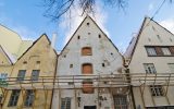 The exterior of three old buildings awaiting a restoration project. A large connecting scaffold is on the buildings.