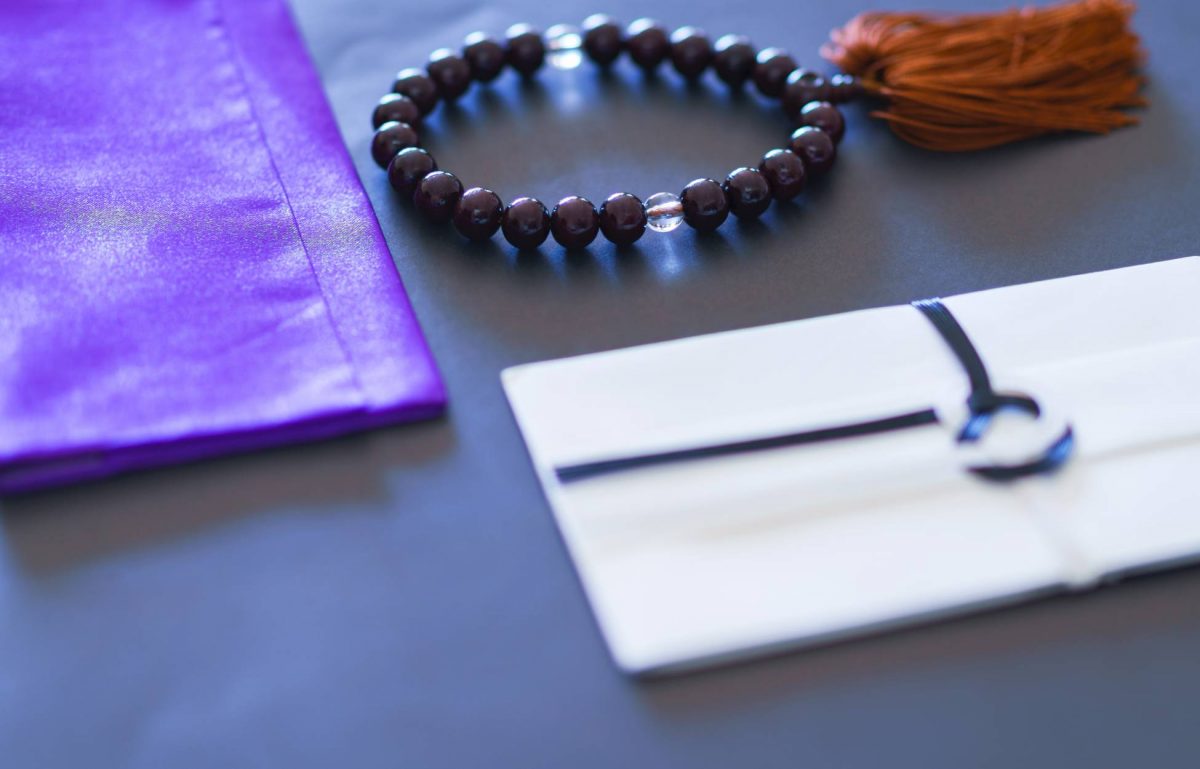 A small collection of First Communion jewelry as a gift. There's a purple bracelet bag and a beaded bracelet next to it.